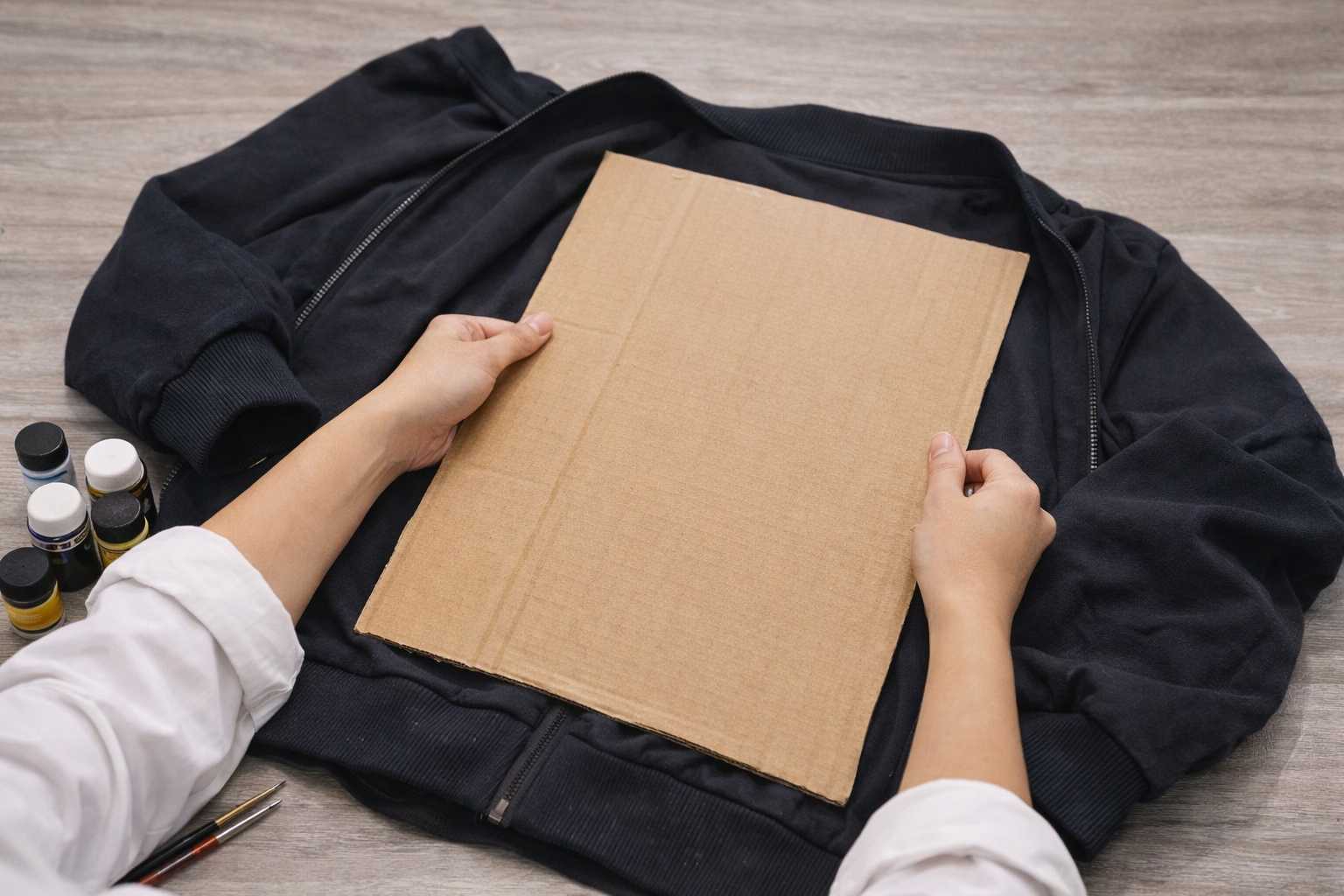 Để màu không bị lem sang phần sau áo bạn nên đặt một tấm bìa cứng trong áo
